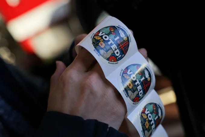A volunteer at a polling station holds stickers during California's special election on Proposition 50 in San Francisco on November 4. Carlos Barria/Reuters